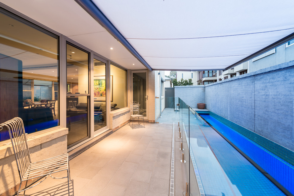 This is an example of a contemporary backyard deck in Adelaide with an awning.