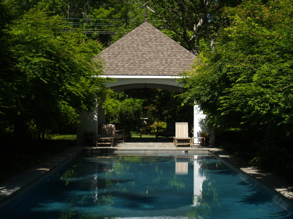 Photo of a mid-sized traditional backyard rectangular pool in New Orleans with natural stone pavers.