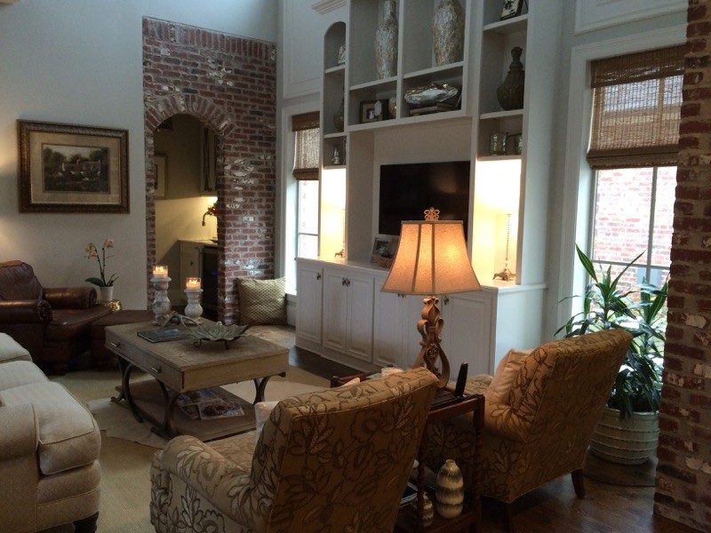 Photo of a large transitional open concept family room in New Orleans with beige walls, dark hardwood floors, a standard fireplace, a brick fireplace surround and a wall-mounted tv.