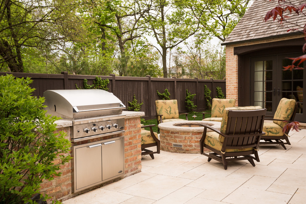 Large traditional backyard full sun garden in Chicago with a fire feature and natural stone pavers for spring.