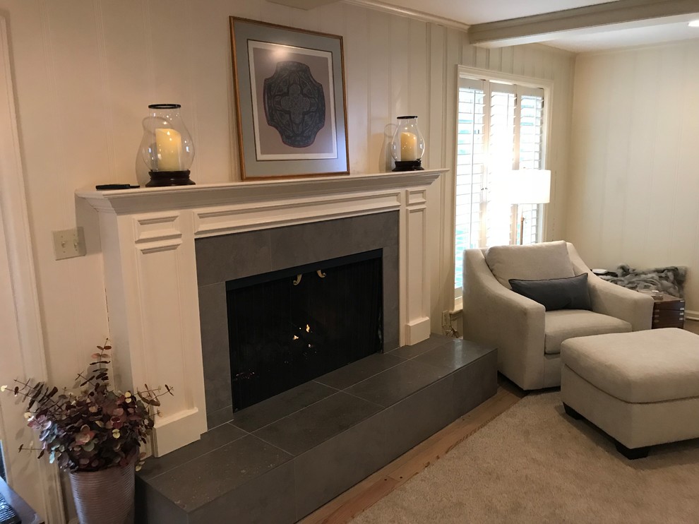 Large transitional open concept family room in Other with beige walls, light hardwood floors, a standard fireplace, a stone fireplace surround, a wall-mounted tv and grey floor.