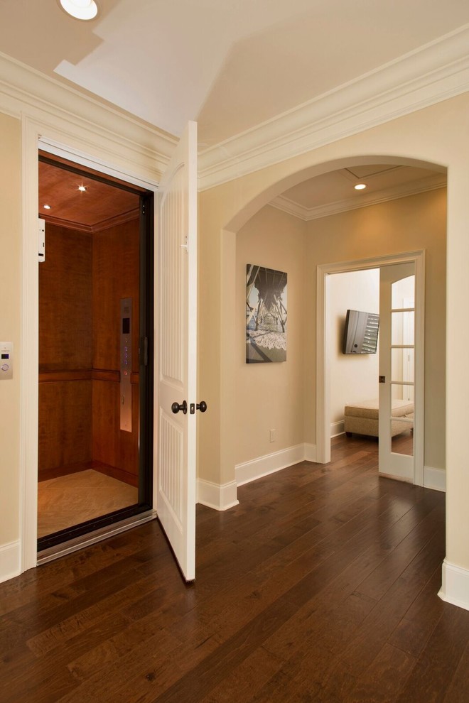 This is an example of a mid-sized traditional hallway in Other with beige walls, dark hardwood floors and brown floor.