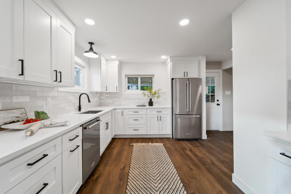 Transitional galley dark wood floor and brown floor eat-in kitchen photo in Seattle with shaker cabinets, white cabinets, quartzite countertops, gray backsplash, ceramic backsplash, stainless steel appliances, no island, white countertops and an undermount sink
