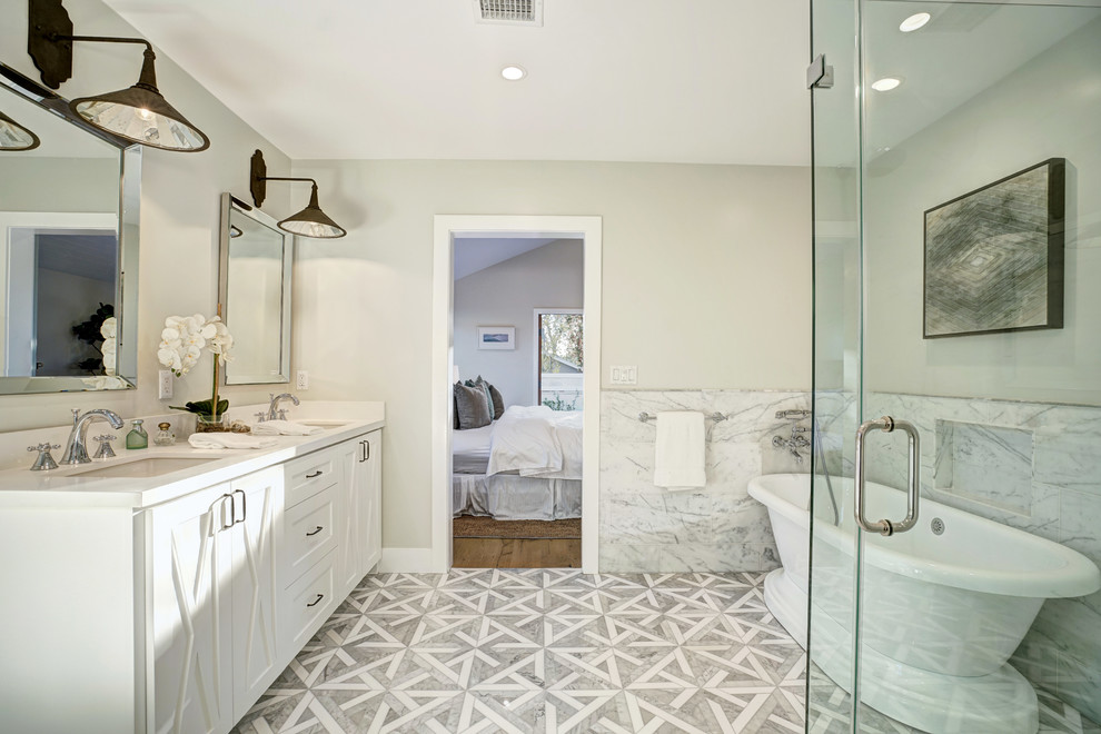 Country master bathroom in Los Angeles with shaker cabinets, white cabinets, a freestanding tub, a corner shower, marble, beige walls, marble floors, an undermount sink, grey floor, a hinged shower door and white benchtops.
