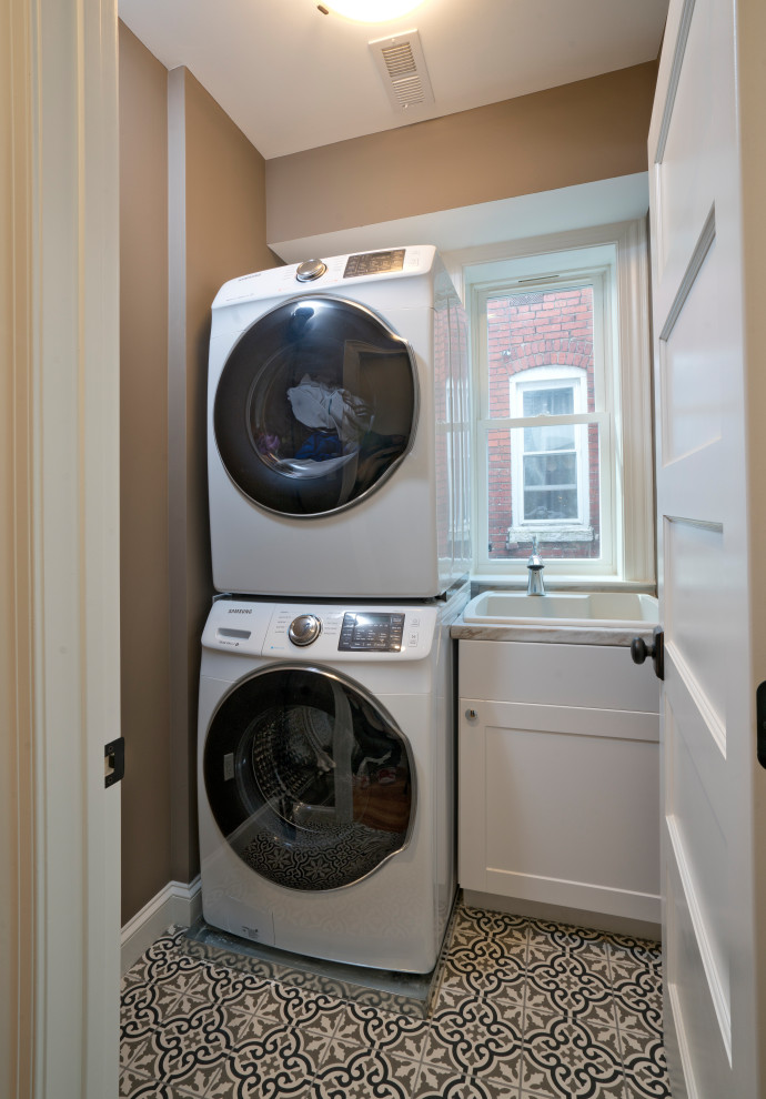 Inspiration for a traditional laundry room in DC Metro with an utility sink and a stacked washer and dryer.