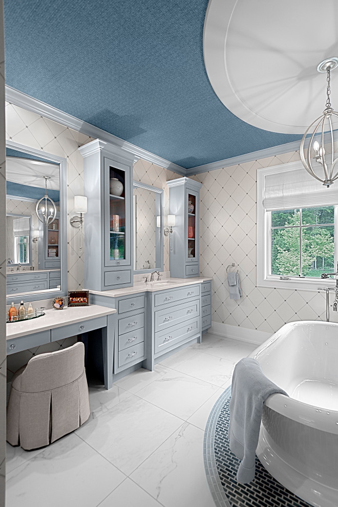 Inspiration for a large traditional master bathroom in Grand Rapids with shaker cabinets, blue cabinets, a freestanding tub, an open shower, beige walls, ceramic floors, an undermount sink, engineered quartz benchtops, multi-coloured floor, white benchtops, an enclosed toilet, a single vanity, a built-in vanity and wallpaper.