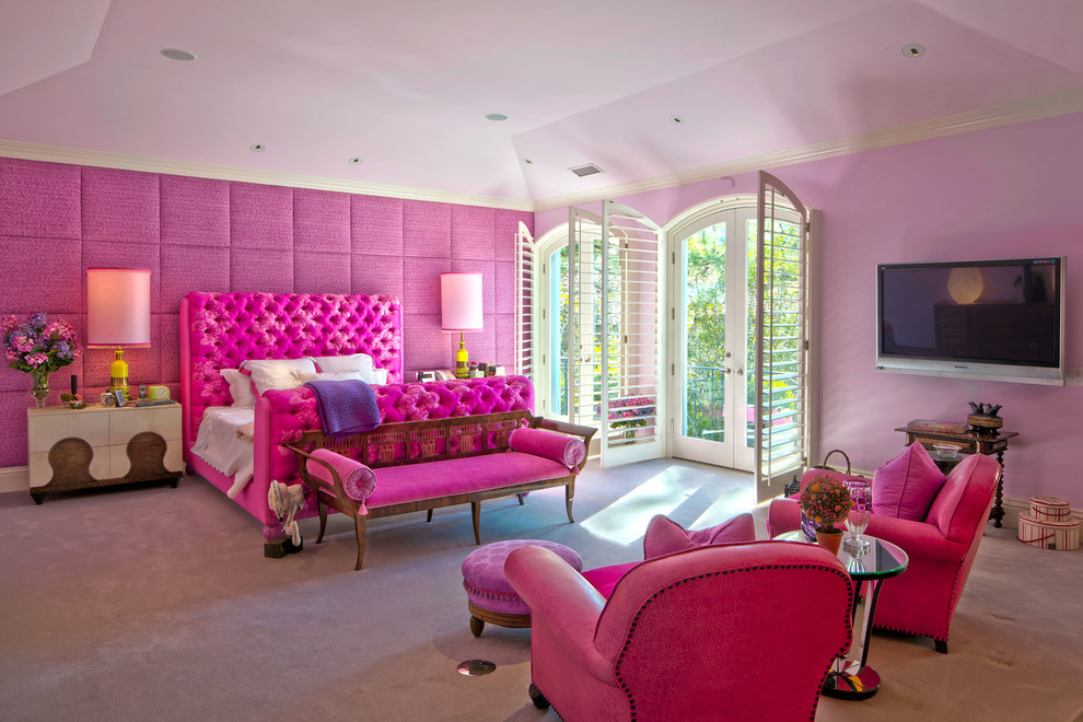 Large eclectic master bedroom in Los Angeles with pink walls, carpet, no fireplace and grey floor.