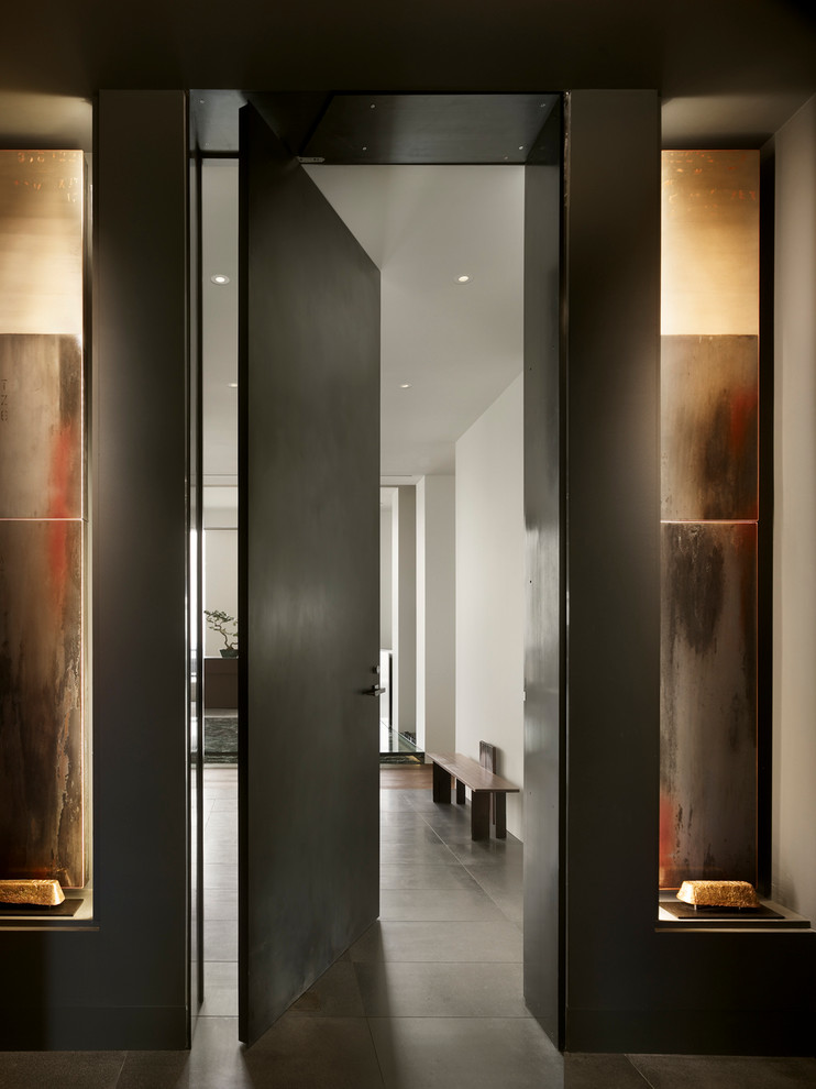 Example of a huge trendy entry hall design in Philadelphia with black walls and a metal front door