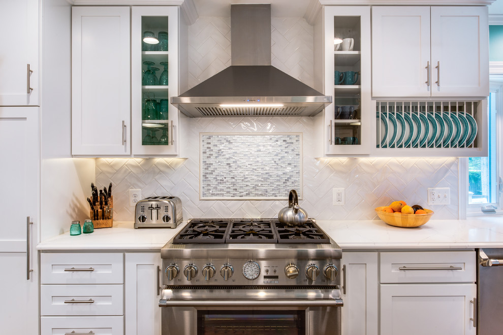 Eat-in kitchen - large transitional galley medium tone wood floor and brown floor eat-in kitchen idea in DC Metro with a farmhouse sink, shaker cabinets, white cabinets, quartz countertops, white backsplash, ceramic backsplash, stainless steel appliances, an island and white countertops