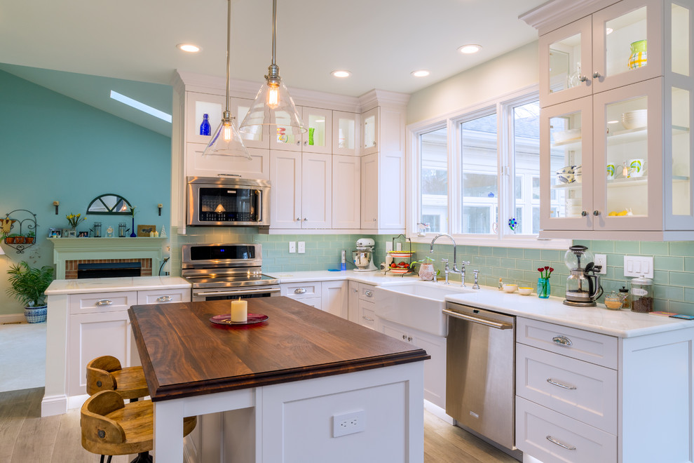 Design ideas for a transitional l-shaped eat-in kitchen in DC Metro with a farmhouse sink, recessed-panel cabinets, white cabinets, blue splashback, subway tile splashback, stainless steel appliances, with island, quartzite benchtops and porcelain floors.