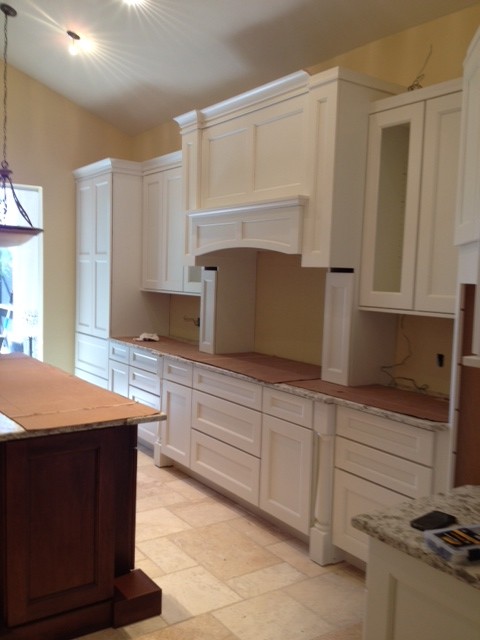 Example of a large transitional travertine floor open concept kitchen design with shaker cabinets, white cabinets, stainless steel appliances, an island, an undermount sink, quartz countertops, beige backsplash and stone tile backsplash