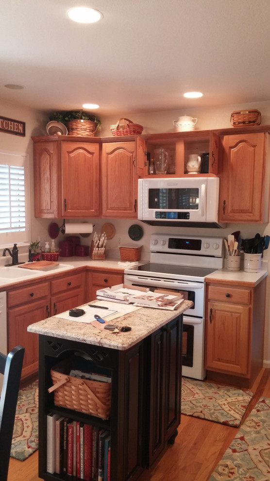 Photo of a small traditional u-shaped eat-in kitchen in Denver with white cabinets, granite benchtops, white appliances and with island.