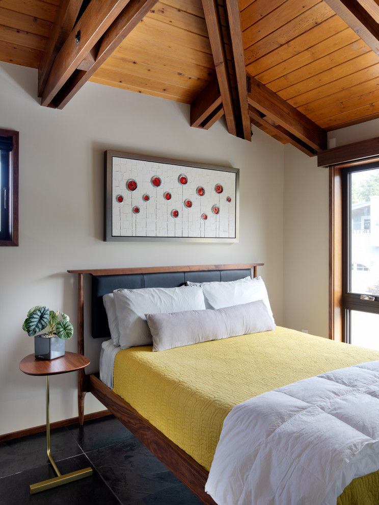 Midcentury bedroom in Portland with beige walls, black floors, exposed beams, a vaulted ceiling and a wood ceiling.