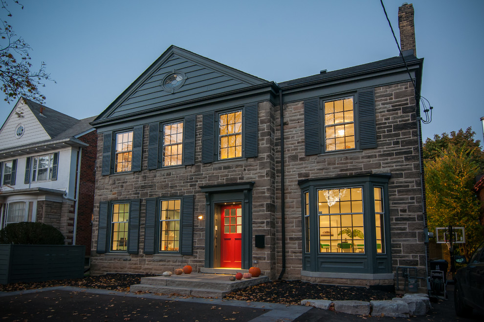 This is an example of a large eclectic two-storey grey exterior in Toronto with stone veneer.