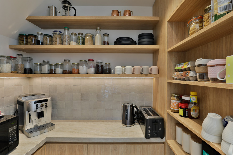 Immagine di una cucina minimalista di medie dimensioni con paraspruzzi grigio, paraspruzzi con piastrelle in pietra, elettrodomestici in acciaio inossidabile e pavimento in laminato