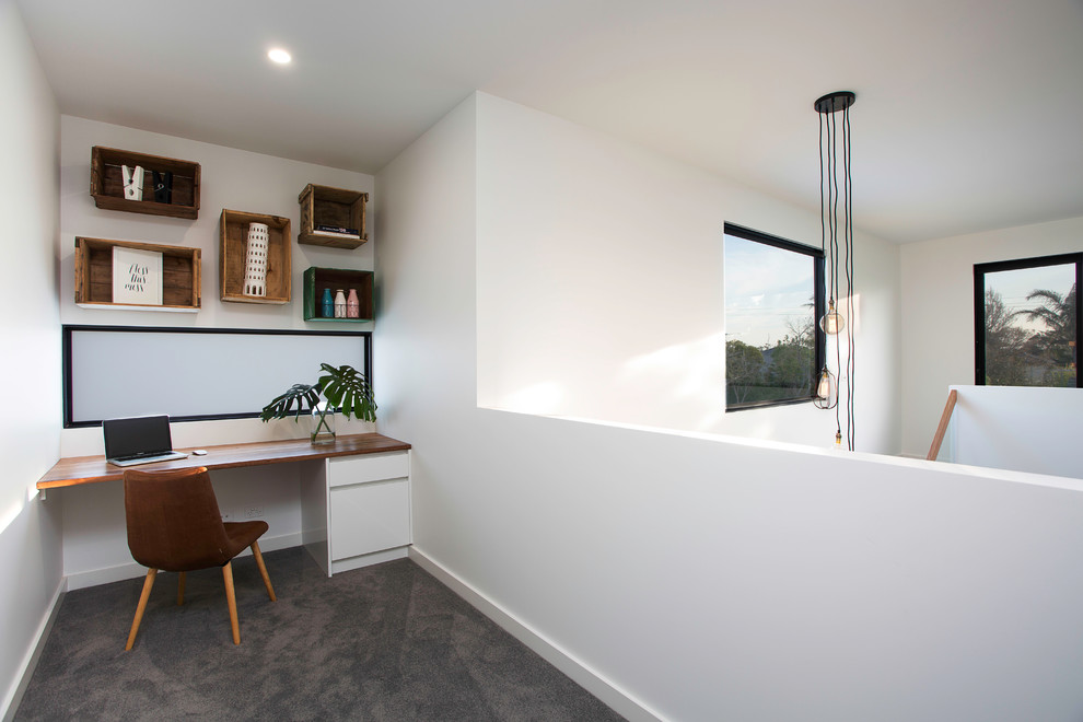 Inspiration for a contemporary study room in Melbourne with white walls, carpet, no fireplace, a built-in desk and grey floor.