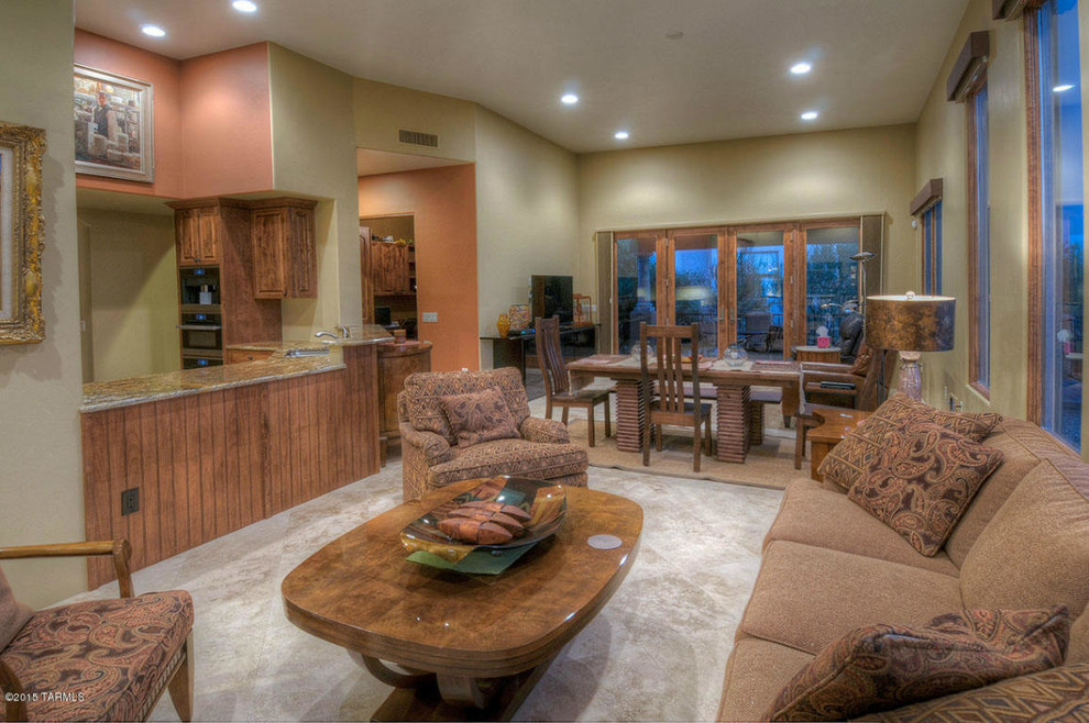 Example of a mid-sized classic l-shaped ceramic tile eat-in kitchen design in Phoenix with a drop-in sink, raised-panel cabinets, brown cabinets, granite countertops and stainless steel appliances
