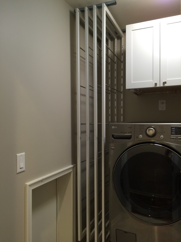 Photo of a small contemporary single-wall laundry room in Minneapolis with wood benchtops, grey walls and a side-by-side washer and dryer.