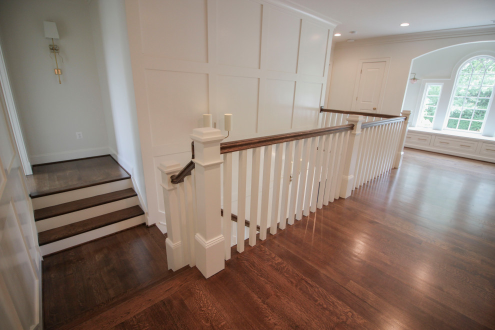 Design ideas for a large transitional wood u-shaped staircase in DC Metro with wood risers, wood railing and decorative wall panelling.