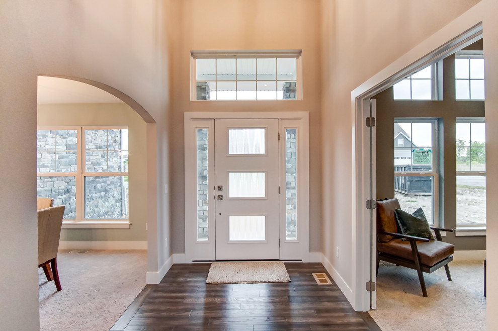 Mid-sized transitional dark wood floor and brown floor front door photo with beige walls and a white front door