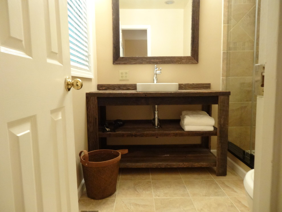 Photo of a small country 3/4 bathroom in Charlotte with a drop-in sink, furniture-like cabinets, dark wood cabinets, wood benchtops, an alcove shower, a two-piece toilet, beige tile, ceramic tile, beige walls and ceramic floors.