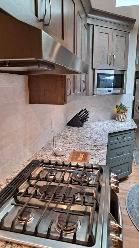 Kitchen - mid-sized transitional galley light wood floor kitchen idea in Denver with shaker cabinets, porcelain backsplash and stainless steel appliances