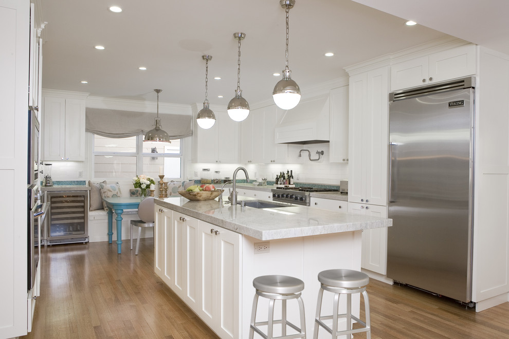 Inspiration for a traditional galley kitchen in San Francisco with stainless steel appliances, an undermount sink, shaker cabinets, white cabinets, white splashback and subway tile splashback.