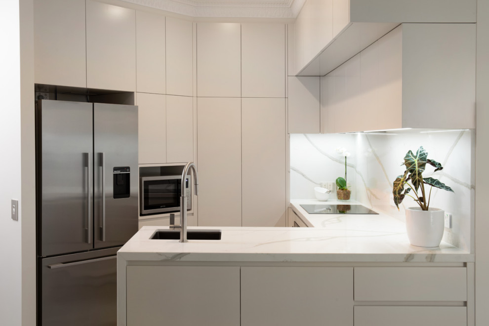 Inspiration for a small contemporary l-shaped open plan kitchen in Brisbane with an undermount sink, flat-panel cabinets, beige cabinets, quartz benchtops, white splashback, engineered quartz splashback, stainless steel appliances, porcelain floors, no island, grey floor, white benchtop and recessed.