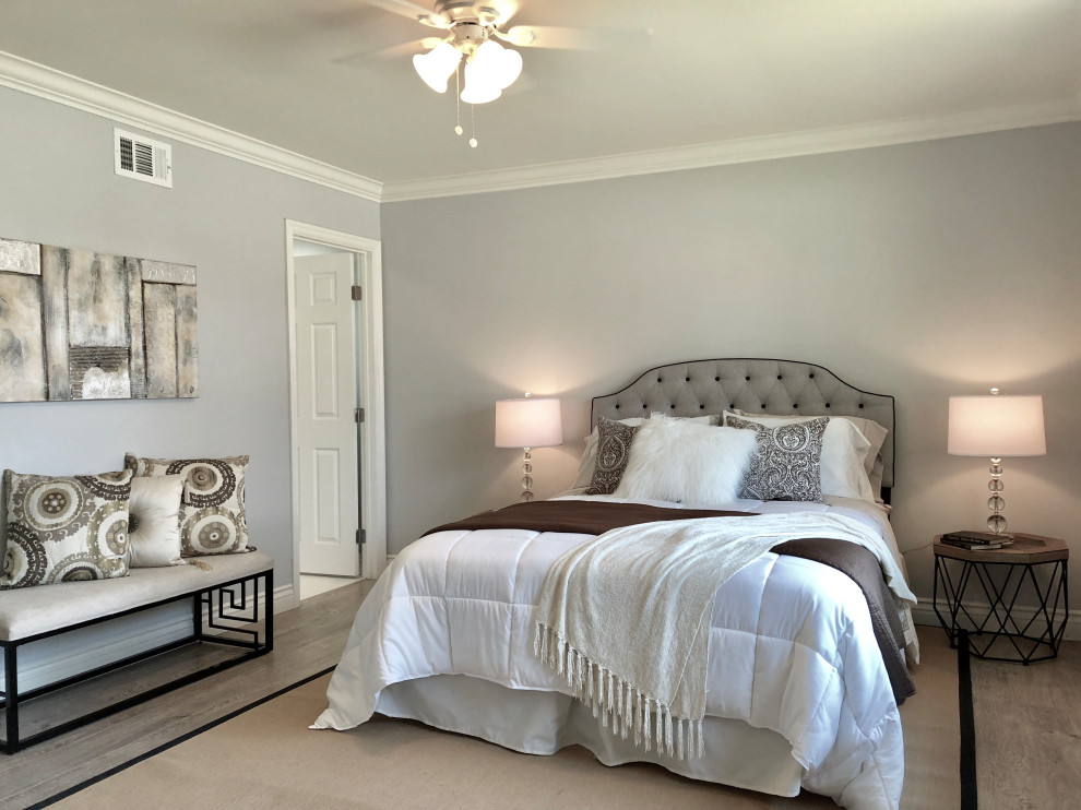 Photo of a mid-sized transitional master bedroom in Orange County with grey walls and grey floor.