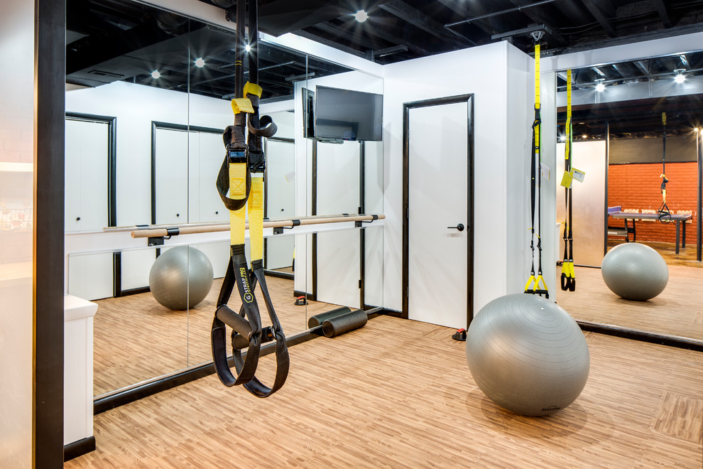 This is an example of a small industrial multipurpose gym in Columbus with white walls and cork floors.
