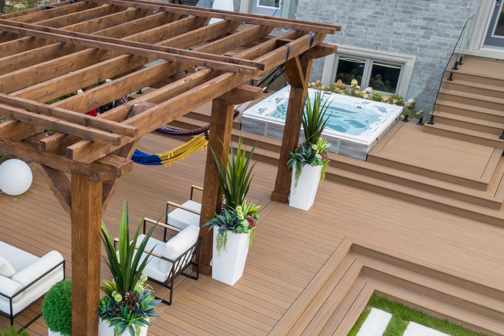 Example of a mid-sized transitional backyard ground level deck container garden design in Toronto with a pergola