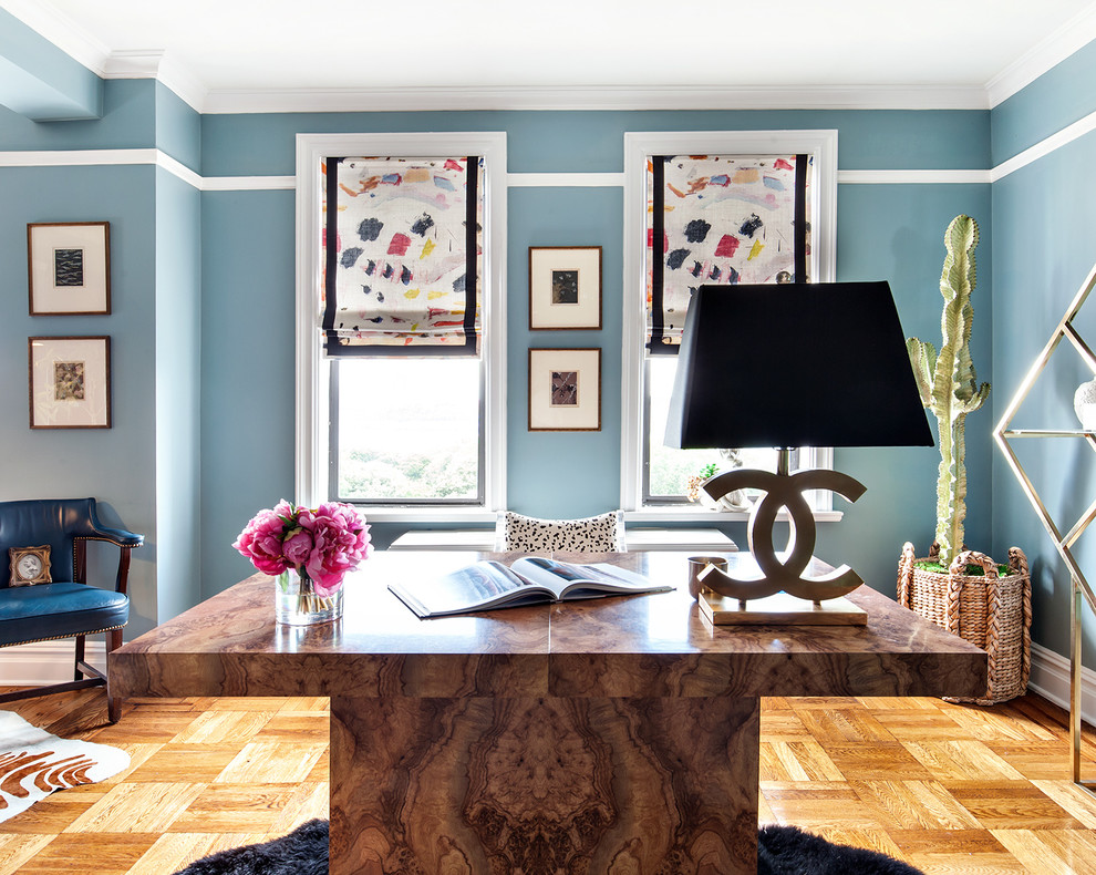 Inspiration for a mid-sized eclectic study room in New York with blue walls, medium hardwood floors, no fireplace, a freestanding desk and brown floor.