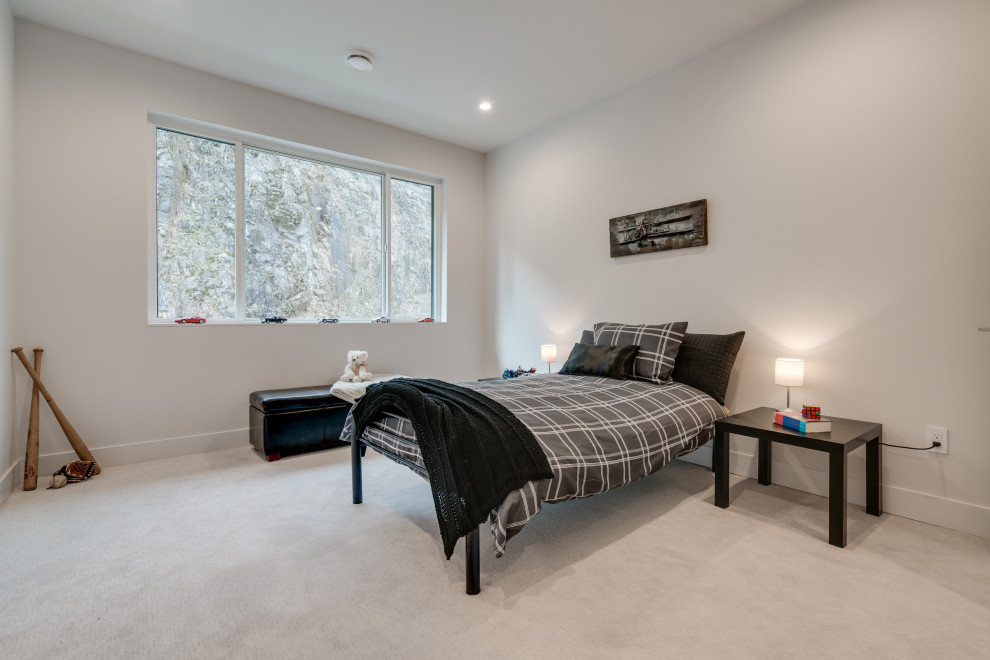 This is an example of a mid-sized contemporary kids' bedroom for boys and kids 4-10 years old in Vancouver with white walls, carpet and grey floor.