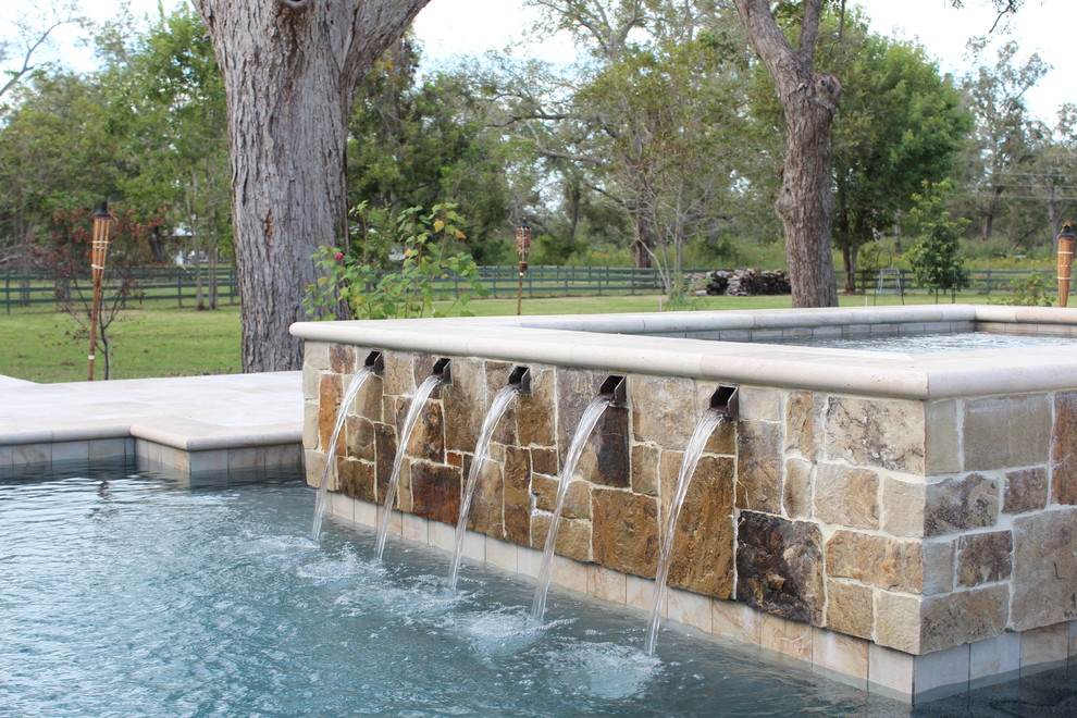 Large transitional backyard stone and rectangular lap hot tub photo in Houston