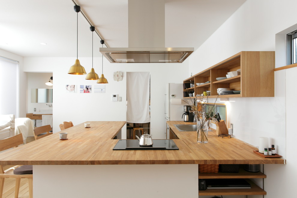 Photo of an asian u-shaped kitchen in Other with a single-bowl sink, white splashback, light hardwood floors and brown floor.