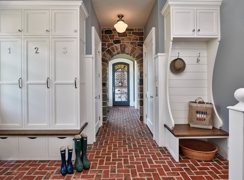 Inspiration for a country mudroom in Philadelphia with grey walls, brick floors, a single front door, a gray front door and red floor.
