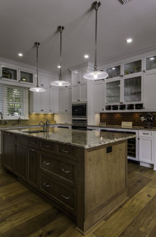 Design ideas for a large transitional u-shaped eat-in kitchen in Tampa with an undermount sink, shaker cabinets, white cabinets, granite benchtops, brown splashback, glass tile splashback, stainless steel appliances, dark hardwood floors, with island, brown floor and beige benchtop.