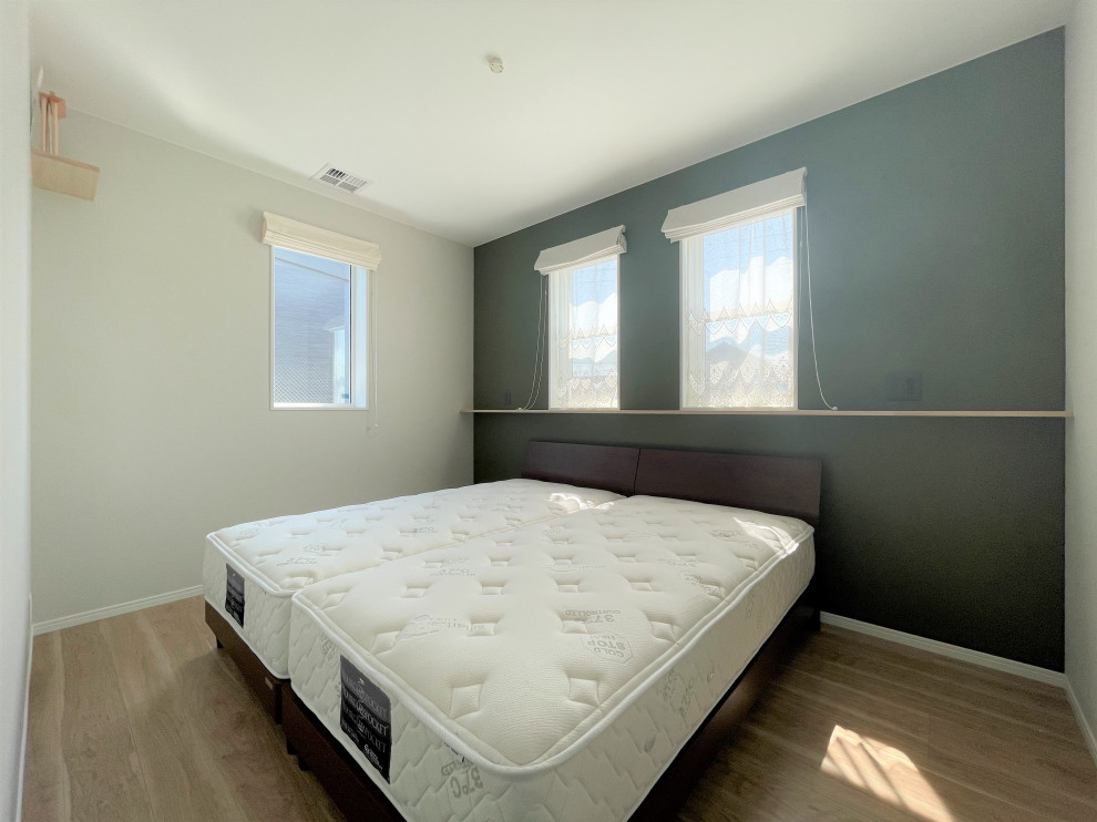 Ejemplo de dormitorio principal y blanco campestre con paredes verdes, suelo de contrachapado, suelo beige, papel pintado y papel pintado