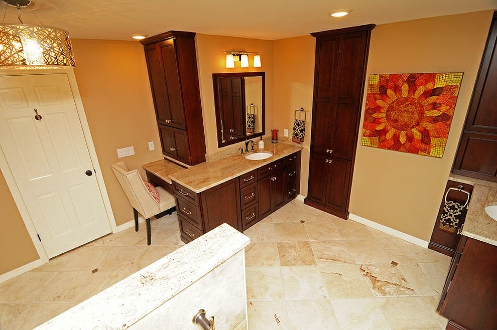 Large elegant master beige tile and stone tile travertine floor corner shower photo in Tampa with an undermount sink, recessed-panel cabinets, dark wood cabinets, granite countertops, a two-piece toilet and orange walls