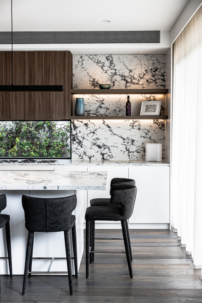 Inspiration for an expansive contemporary galley open plan kitchen in Other with a built-in sink, flat-panel cabinets, dark wood cabinets, marble worktops, multi-coloured splashback, marble splashback, stainless steel appliances, dark hardwood flooring, an island, brown floors and multicoloured worktops.