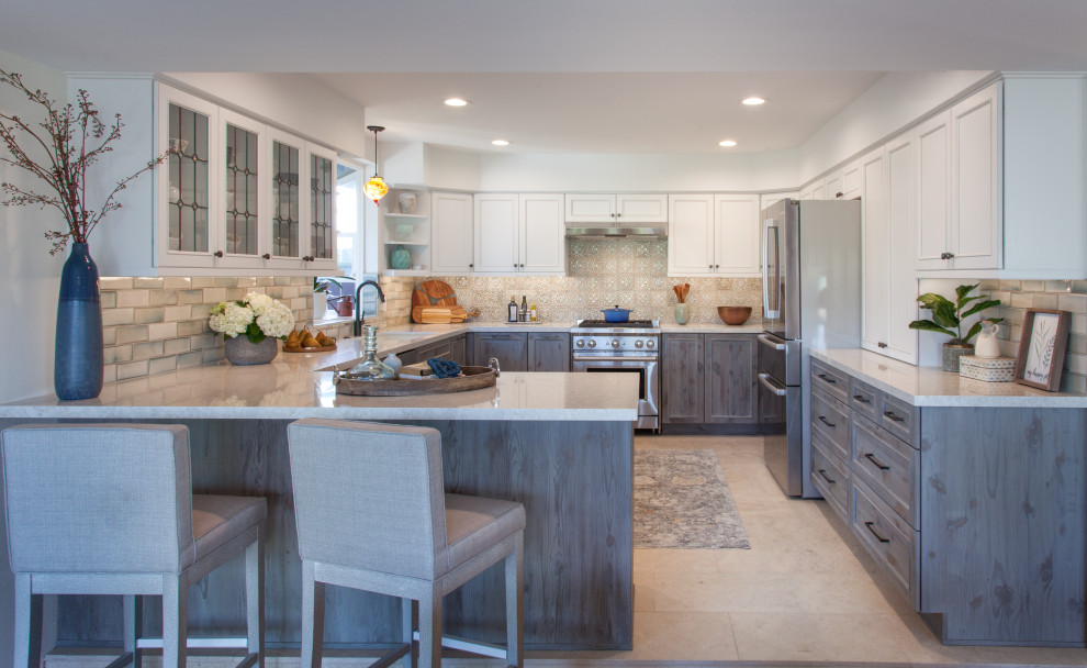 Mid-sized transitional u-shaped eat-in kitchen in San Diego with an undermount sink, shaker cabinets, distressed cabinets, quartz benchtops, blue splashback, ceramic splashback, stainless steel appliances, porcelain floors, beige floor and white benchtop.