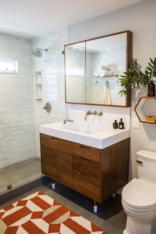 Photo of a mid-sized contemporary 3/4 bathroom in Orange County with flat-panel cabinets, medium wood cabinets, an alcove shower, a two-piece toilet, gray tile, white tile, matchstick tile, grey walls, porcelain floors and a trough sink.