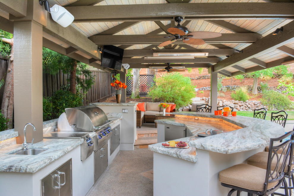 This is an example of a large transitional backyard patio in San Francisco with an outdoor kitchen and a gazebo/cabana.