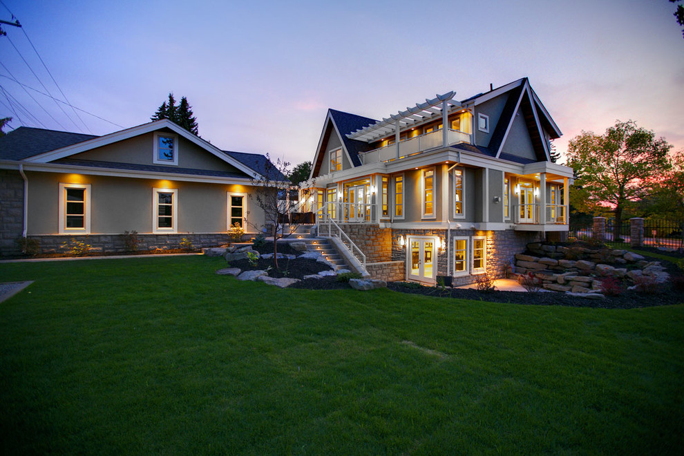 This is an example of a large transitional three-storey grey exterior in Calgary with mixed siding and a gable roof.
