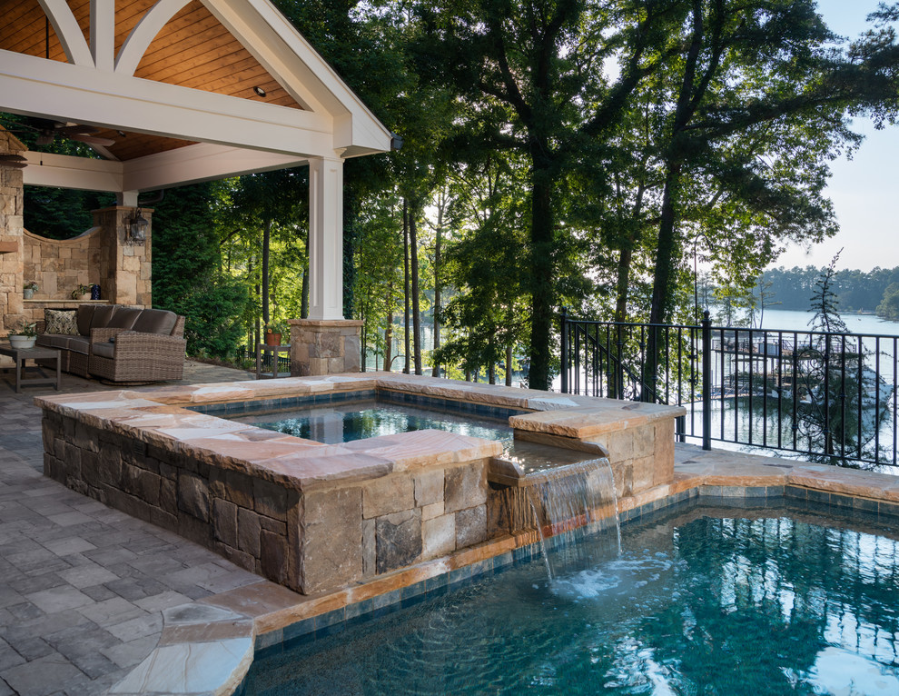 Design ideas for a large traditional backyard rectangular infinity pool in Atlanta with a water feature and concrete pavers.