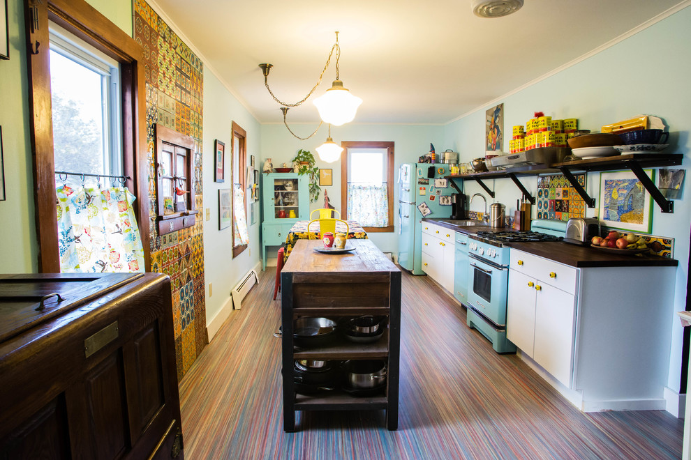 Photo of a mid-sized eclectic galley eat-in kitchen in Burlington with white cabinets, wood benchtops, coloured appliances and with island.