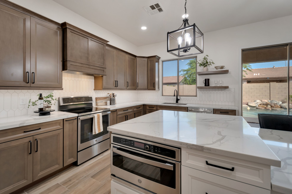 Mid-sized transitional u-shaped ceramic tile and brown floor eat-in kitchen photo in Phoenix with beaded inset cabinets, brown cabinets, quartzite countertops, white backsplash, ceramic backsplash, an island and white countertops
