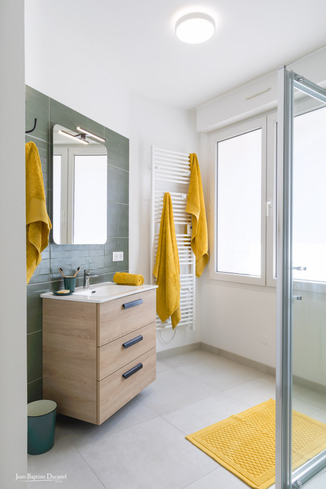 Inspiration for a medium sized shower room bathroom in Paris with flat-panel cabinets, light wood cabinets, a corner shower, a one-piece toilet, green tiles, ceramic tiles, a wall-mounted sink, a hinged door, white worktops, a single sink, a floating vanity unit, beige walls, laminate floors and brown floors.