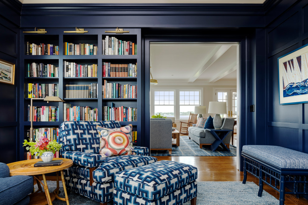 Idee per un soggiorno costiero aperto con libreria, pareti blu, pavimento in legno massello medio, nessuna TV, pavimento marrone e pannellatura