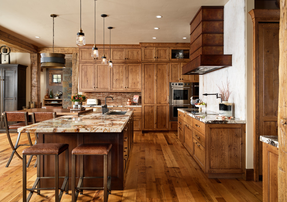 Inspiration for a large rustic l-shaped medium tone wood floor and multicolored floor open concept kitchen remodel in Denver with an undermount sink, recessed-panel cabinets, medium tone wood cabinets, granite countertops, brown backsplash, stone tile backsplash, stainless steel appliances, two islands and multicolored countertops